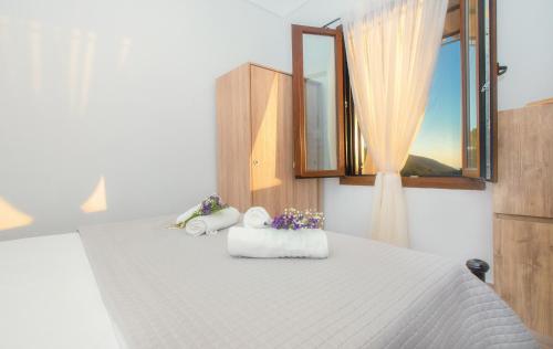 a bedroom with a bed with towels and a window at CHEZ KONSTANTINOS in Kallirakhi