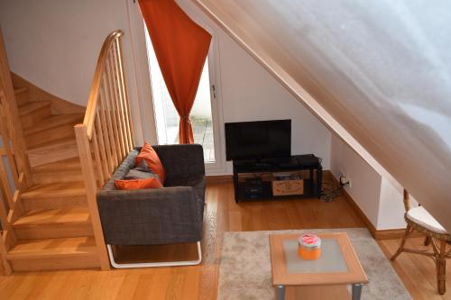 a living room with a chair and a television at Cape Cod in Wimereux