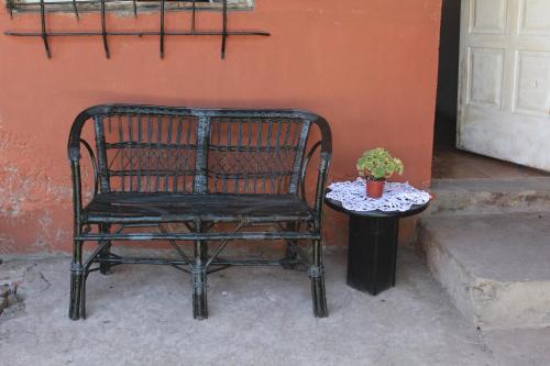 a black chair and a table with a potted plant at HOSTEL la Casa del Patio BB in Bahía Blanca