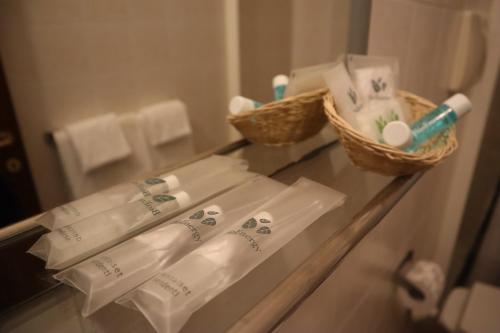 a bathroom counter with towels and a basket of toiletries at Albergo Salerno in Milan