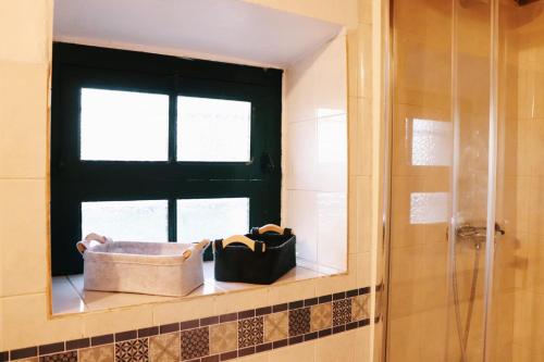 una ventana en un baño con una cesta en un estante en Monte das Cobras - Country House, en Évora
