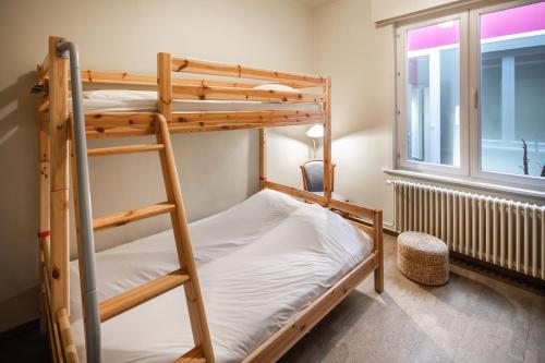 a bunk bed room with two bunk beds and a window at Parkhotel in De Panne