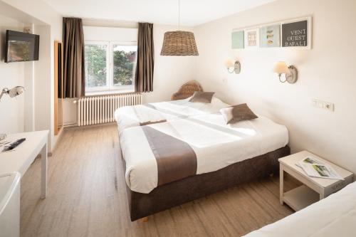 a hotel room with a bed and a desk at Parkhotel in De Panne