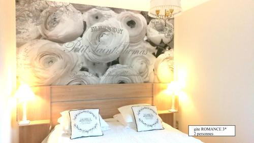 sypialnia z łóżkiem ze ścianą z białymi różami w obiekcie Doubs Le Cadran Solaire, gite ROMANCE class 3 étoiles w mieście Sancey-le-Grand