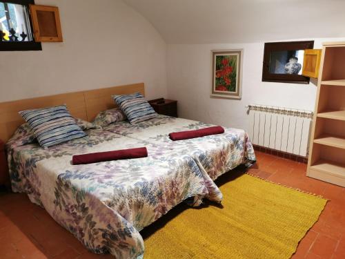 a bedroom with a bed with pillows and a yellow rug at Can Resiu in Serinyà