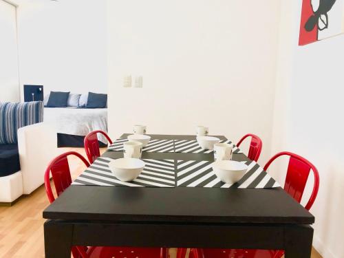 a black table with red chairs in a living room at Apartamentos de Maria en Martinez! Av Libertador con Patio! in Martínez