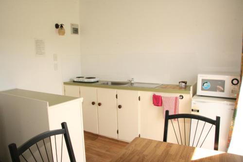 a kitchen with a sink and a table with chairs at Whangarei Central Holiday Park in Whangarei