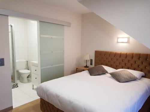 um quarto com uma cama grande e uma casa de banho em Hôtel Méribel em Bruxelas