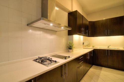 a kitchen with a stove and a counter top at Wedgewood Residences in Kuala Lumpur
