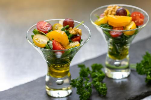 two vases filled with fruit and vegetables on a table at hotel bomonti Nürnberg West in Oberasbach