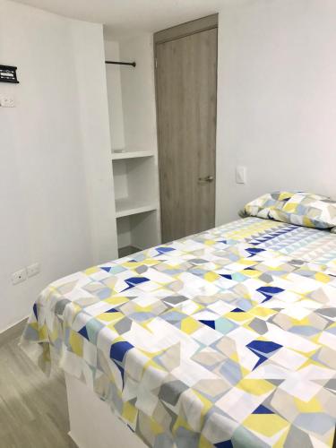 1 dormitorio con 1 cama con colcha colorida en Caribbean Venture Apto 303 - Rodadero, Santa Marta, en Santa Marta