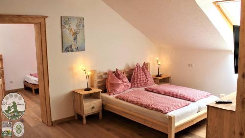 a bedroom with a bed with red pillows at Kinderparadies Bachbauer in Mondsee