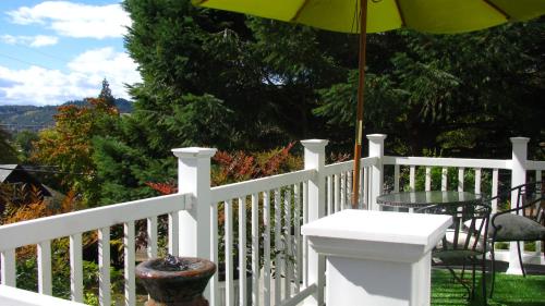 a white fence with a table and an umbrella at Terraluna Inn in Roseburg