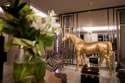 a gold horse statue on a table in a room at Hotel Traugutta3 in Białystok