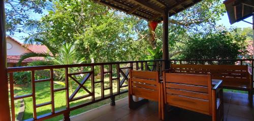 a balcony with two benches and a view of trees at Hong Bin Bungalow in Phu Quoc