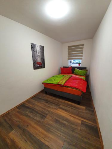 een slaapkamer met een bed met groene en rode kussens bij Eddy's Stadt Stübchen in Quedlinburg