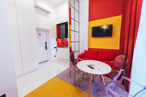 sala de estar con sofá rojo y mesa en Cities Gallery Apart-hotel en Leópolis