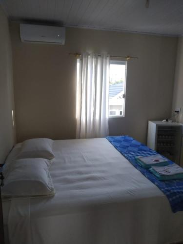 a bedroom with a white bed with a window at Pousadas Mafra in Mafra