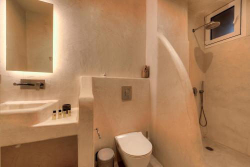 a bathroom with a toilet and a sink and a shower at The Muses of Santorini Private Jacuzzi Suites in Vóthon