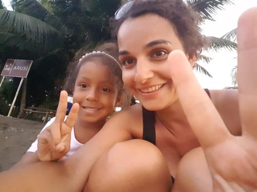 a woman and a girl sitting on the beach at Casa Colibrí in Nuquí