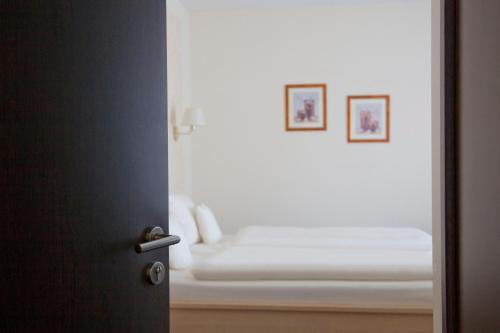 a room with a bed with two pictures on the wall at City-Hotel in Friesoythe