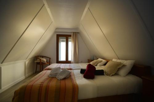 a bedroom with a large bed in an attic at Chalé Acolhedor - Penhas da Saúde - Serra da Estrela in Covilhã