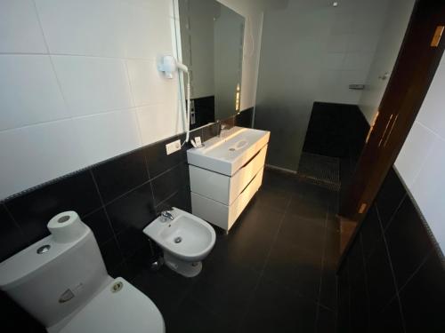 ein Badezimmer mit einem WC, einem Waschbecken und einem Spiegel in der Unterkunft База відпочинку "РіверСайд" in Nowomoskowsk