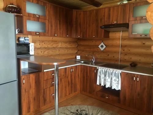 una cocina con armarios de madera y fregadero en Cottage Karinka en Bukovel