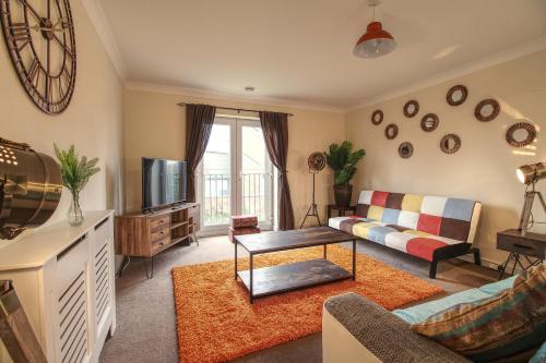 a living room with a couch and a tv at Sunnydale Serviced Apartments - Central Wakefield, spacious apartment in Wakefield