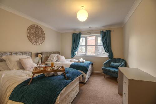 a bedroom with two beds and a table and a chair at Sunnydale Serviced Apartments - Central Wakefield, spacious apartment in Wakefield