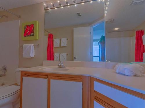 een badkamer met een wastafel, een toilet en een spiegel bij Bluewater Apartments III in Orange Beach