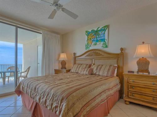 a bedroom with a bed and a view of the ocean at Bluewater Apartments III in Orange Beach