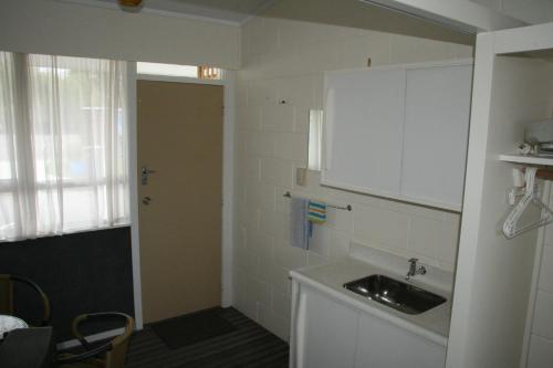 a small kitchen with a sink and a window at Whangarei Central Holiday Park in Whangarei