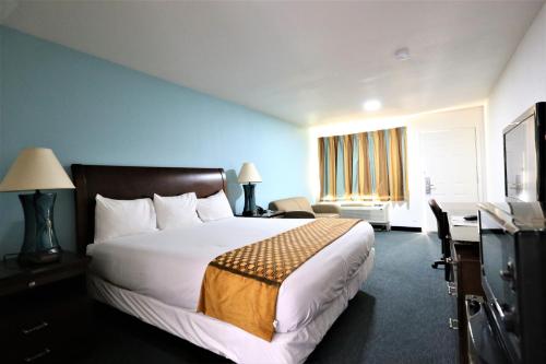 Cuero的住宿－Executive Inn & Suites Cuero，酒店客房设有一张大床和一张书桌。
