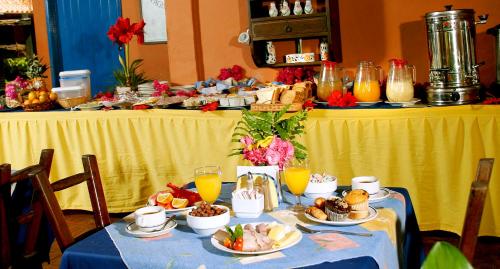 a table topped with plates of food and orange juice at Hotel Costa Linda Beach in La Loma