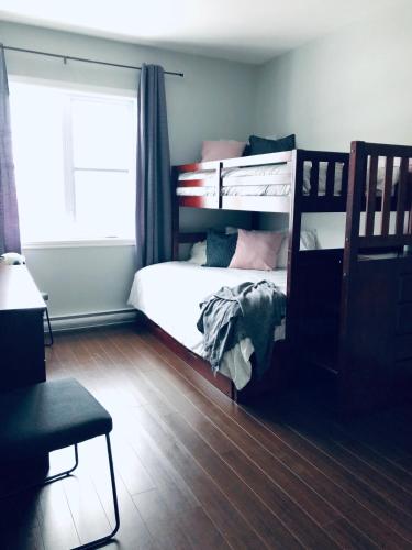 a bedroom with a bunk bed and a window at Splendid Mountain View Condo with Pool & BBQ- Ski, MTB, Cycling, Golf, Telework! in Bromont