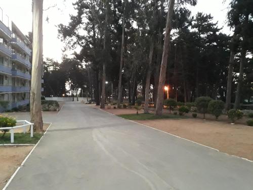 a walkway in a park with trees and a building at Departamento Bosques del Tabo in El Tabo