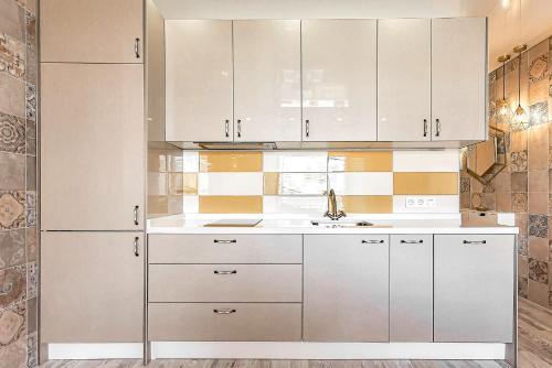 a kitchen with white cabinets and a sink at Luxury apartment Orlando in Adeje