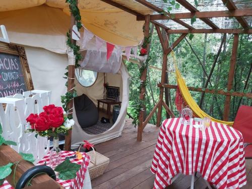 a patio with a tent with a table and flowers at Glamping con sentido in Subachoque