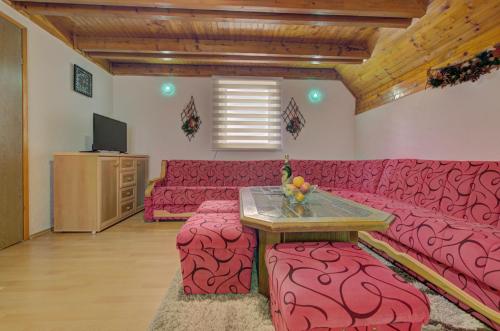 a living room with a red couch and a table at Villa Strahinja Lux Jahorina in Jahorina