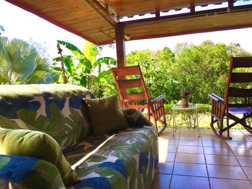 a living room with a couch and chairs on a patio at Hotel Vista Linda Montaña in Alajuela City