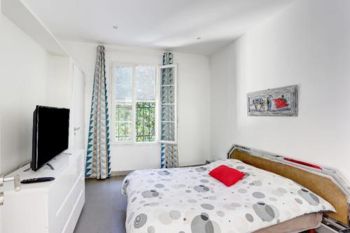 1 dormitorio con 1 cama y TV en Appartements Cannes en Cannes