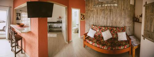a living room with a couch and a kitchen at Chale da Mole in Florianópolis