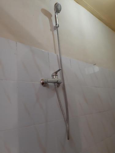 a shower in a bathroom with a microphone on the wall at Patra House in Ubud