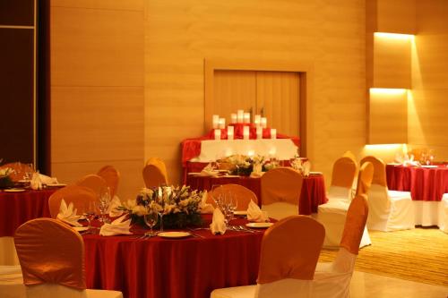 a room with tables and chairs with a cake in the background at Mysore County Retreat in Mysore