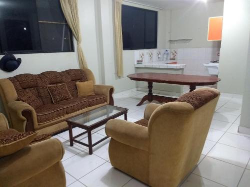 sala de estar con sofá, sillas y mesa en Departamento Melly, en Tarapoto