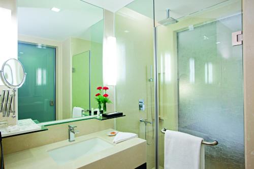 W łazience znajduje się umywalka i przeszklony prysznic. w obiekcie Country Inn & Suites By Radisson, Sahibabad w mieście Ghaziabad