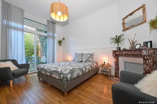 een slaapkamer met een bed en een open haard bij Chambres d'hotes Les Nuits Pastel in Saint-Quentin