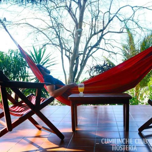 a person laying in a hammock on a patio at Hosteria Cumilinche in Same