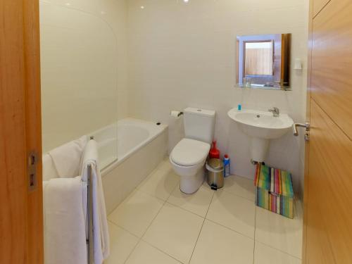 uma casa de banho branca com um WC e um lavatório em Faial Marina Apartments 1 em Horta